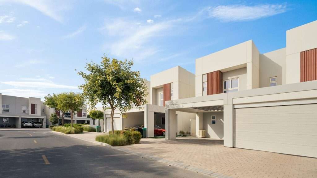 Row of modern residential homes on a sunny day with clear blue sky.